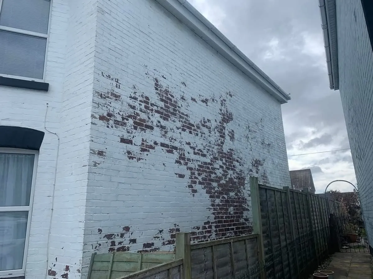 Peeling paint on a brick wall before redecoration in Teignmouth